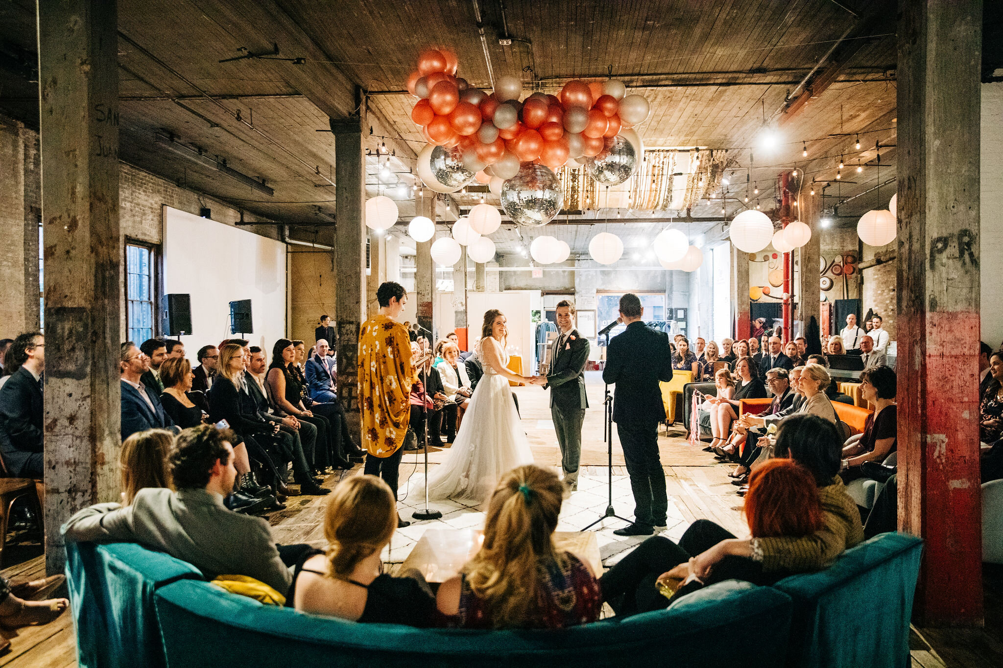 Two marriers getting married in the round with a lounge-like setting.