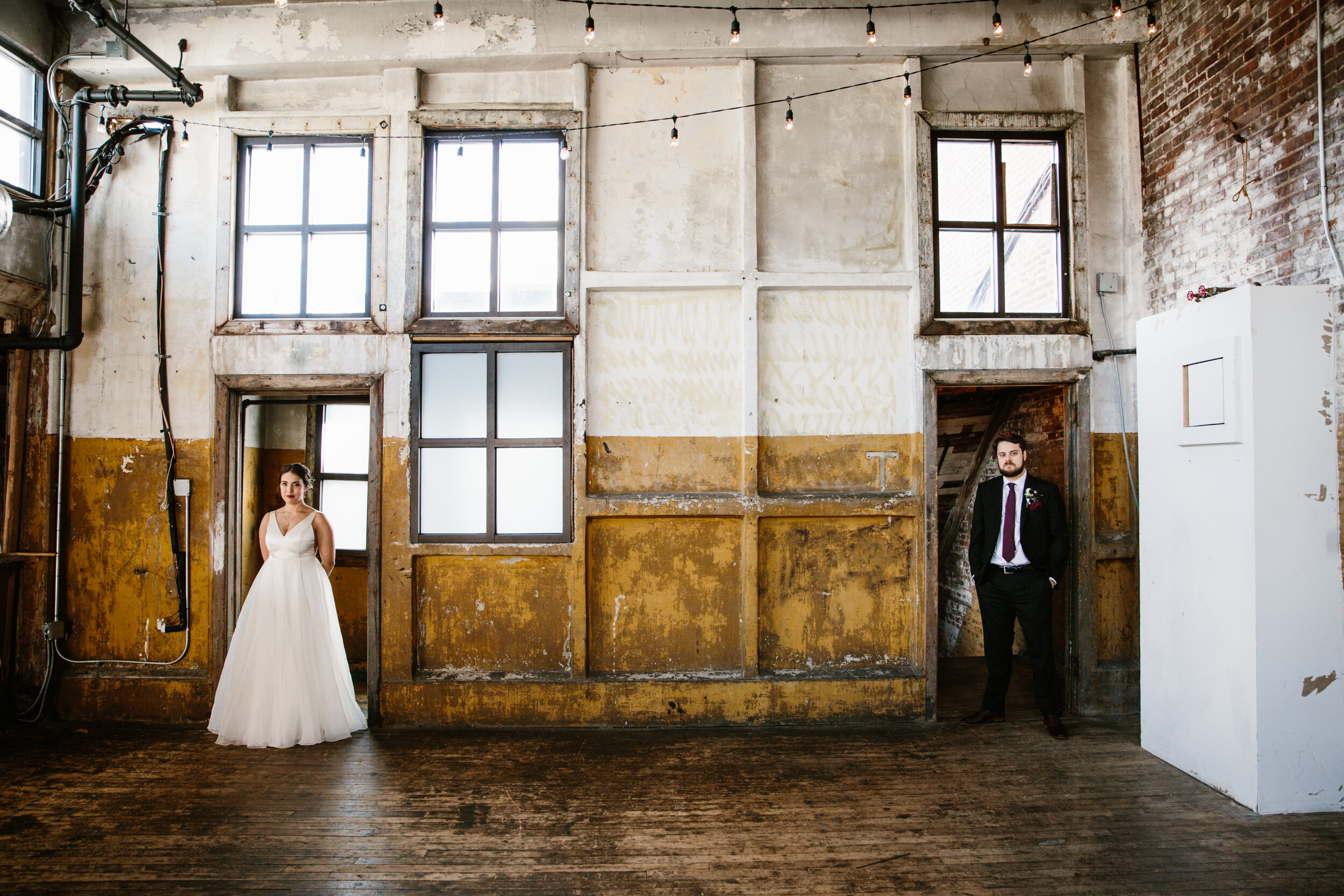 Two marriers stand in a large industrial room in separate doorways.