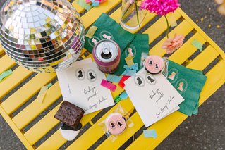 disco balls and napkins sit on a colorful small metal table