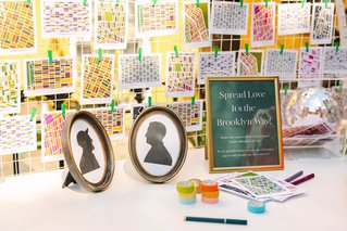 a wall of postcards with a small sign saying "spread love its the brooklyn way"