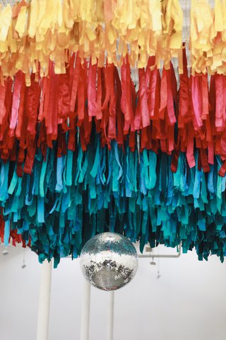 colorful ribbons hang from the ceiling with a disco ball