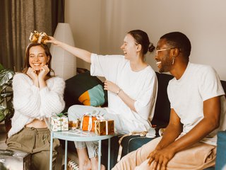 people in a living room exchange gifts