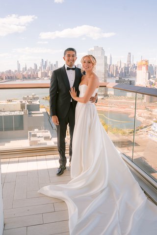 two people stand in front of the NYC skyline