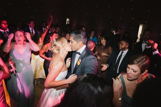 two people kissing on a dance floor