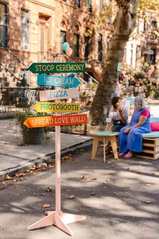 A colorful sign post indicating where wedding events are happening