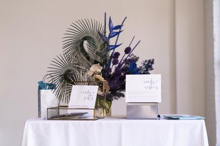 a colorful guest book and card box table at a wedding