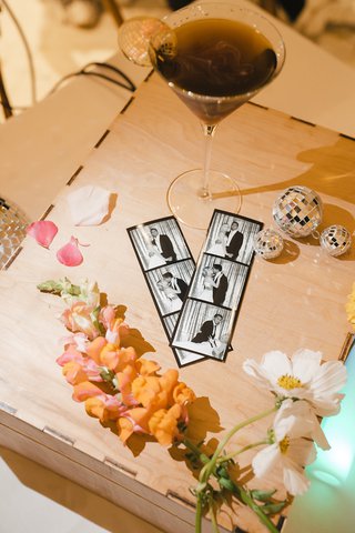 photobooth strips sit on top of a pizza box