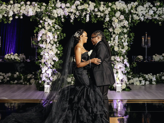 Two Black queer marries stand at the wedding altar holding each other hands smiling