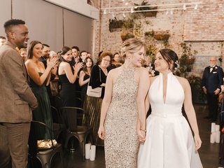 two white women holding hands as they recess down the altar after their wedding ceremony
