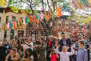 a crowd of people cheer while confetti rains down