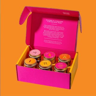 A pink and orange box full of six spice jars